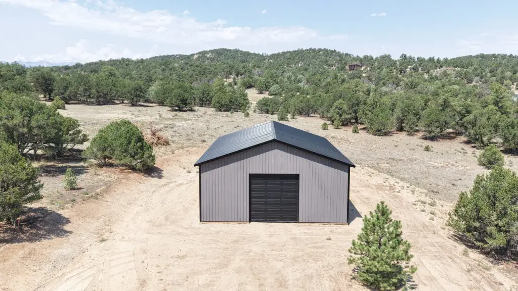 Straight-on aerial view of a black 12x12 CHI overhead door on a 36x48 charcoal storage building in Cotopaxi, Colorado