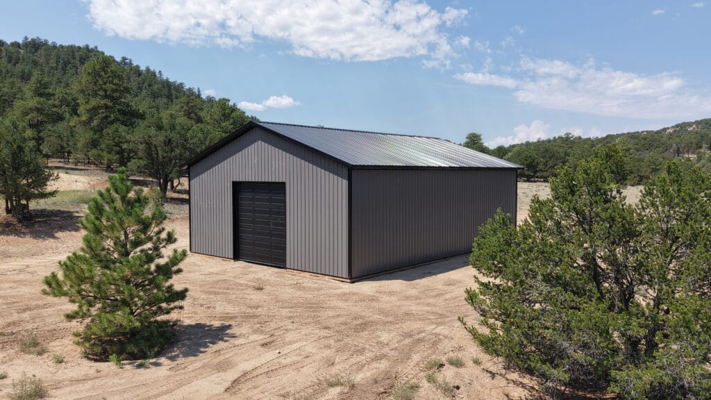 Rear and side aerial view showing a black 12x12 CHI garage door and charcoal metal siding on a camper storage building